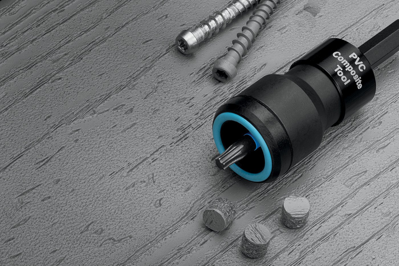 The Starborn Pro Plug System laid out on a grey wood-grain deck board: the PVC and composite setting tool with its blue Auto-Stop collar, two star drive stainless screws with auger tips, and three plugs cut from actual board material