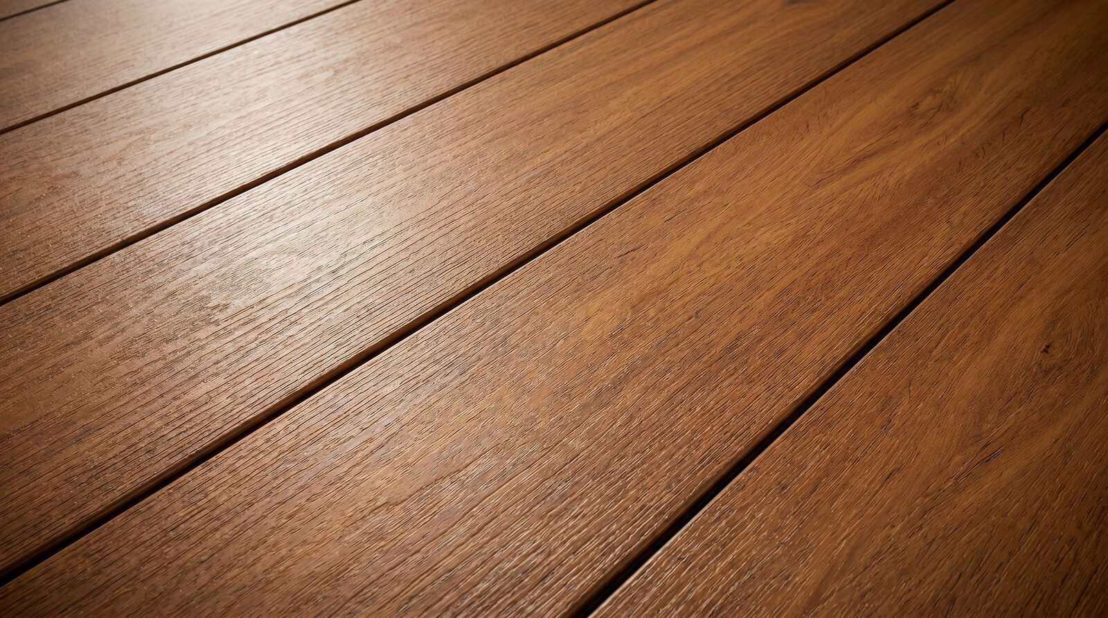 TrueGrain Deck Tropical Walnut PVC decking installed on a coastal home at late-afternoon light