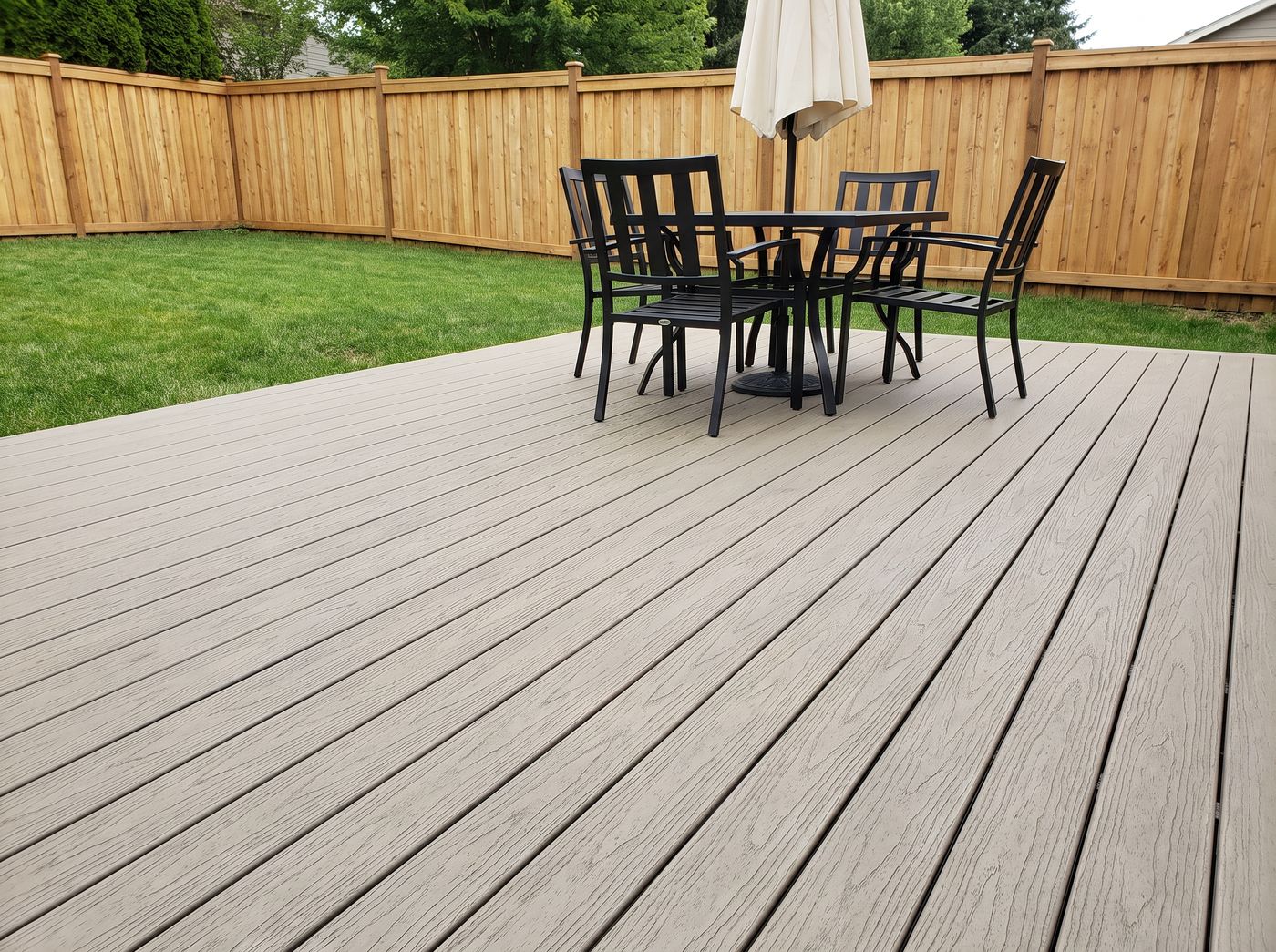 Khaki Legacy PVC decking on a family backyard deck with outdoor dining set