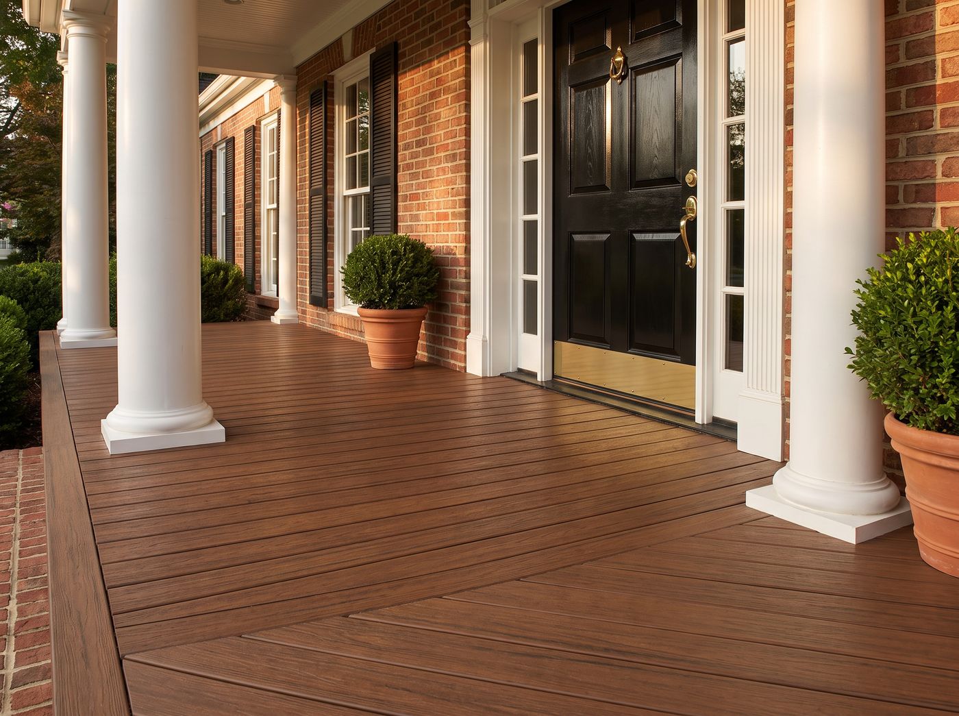 Chestnut PVC tongue and groove porch flooring on a brick colonial front porch at dusk